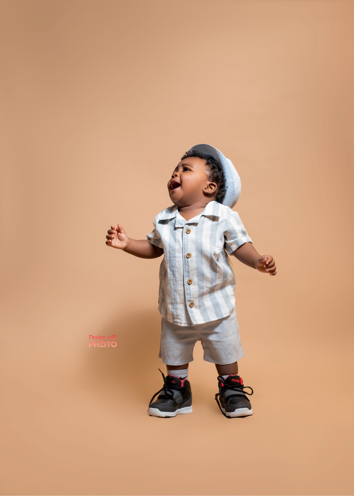Toddler boy in a striped shirt and cap